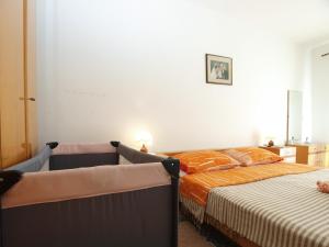 sypialnia z 2 łóżkami z pomarańczową i białą pościelą w obiekcie Apartment Vodnjan 1123 w mieście Vodnjan