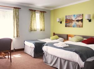 una habitación de hotel con 3 camas en una habitación en The Keelman and Big Lamp Brewery en Newcastle