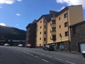 una calle con coches estacionados en el lateral de un edificio en Apartamento Fontargent, en Soldeu