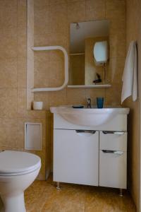 a bathroom with a white sink and a toilet at Apart Petrovskie on Sovetskaya 60 in Tomsk