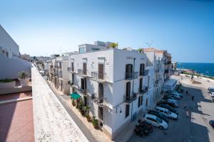 an apartment building with cars parked in a parking lot at Covo dei Saraceni in Polignano a Mare