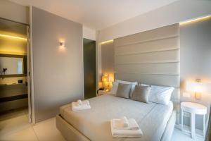 a bedroom with a white bed with two towels on it at Covo dei Saraceni in Polignano a Mare