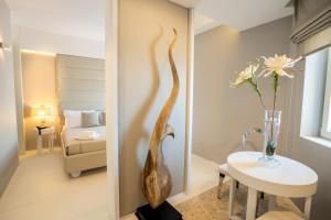 a room with a table and a vase with flowers at Covo dei Saraceni in Polignano a Mare