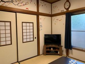 a room with two doors and a tv and a window at Kamata Ann in Tokyo