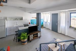 ein Wohnzimmer mit einem TV und einer Küche in der Unterkunft PORT CITY HAIFA - BAT GALIM oceanfront luxury in Haifa