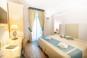a bedroom with a bed and a desk with a laptop at Covo dei Saraceni in Polignano a Mare
