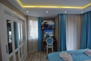 - une chambre avec un lit, un bureau et une télévision dans l'établissement Hayat Rose Hotel, à Uzungöl