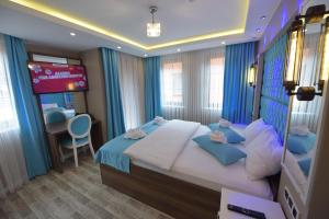 - une chambre avec un grand lit et une télévision dans l'établissement Hayat Rose Hotel, à Uzungöl