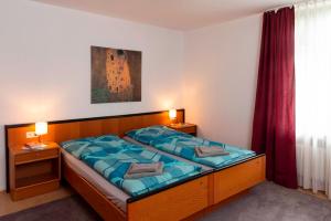 a bedroom with a large bed with blue sheets at Wildbach Appartement in Ober-Hambach