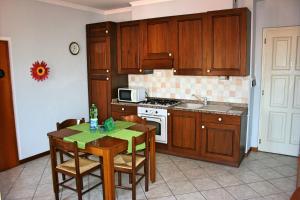 a kitchen with wooden cabinets and a table with chairs at Casa Vacanze Stella in Verbania