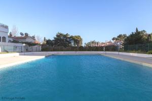a large pool of blue water in a yard at Cascais Panoramic Apartment in Cascais