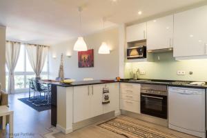 a kitchen with white cabinets and a counter top at Cascais Panoramic Apartment in Cascais