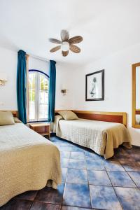 two beds in a room with a ceiling fan at Nautilus Lanzarote in Puerto del Carmen +206 photos