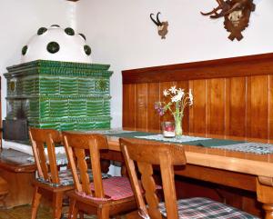 a dining room with a table with chairs and a fireplace at Sport Aktiv Pension Spanner - Tauplitz in Bad Mitterndorf