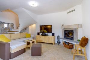 a living room with a couch and a fireplace at Holiday home Verin in Mali Lošinj