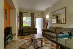 a living room with a couch and a tv at Shonalanga Lodge in St Lucia