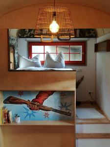 a room with a bed with a painting of a baseball bat at Benno der Zirkuswagen in Tettau