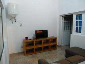 een woonkamer met een tv op een houten standaard bij Apartamento para familias in Marzagán