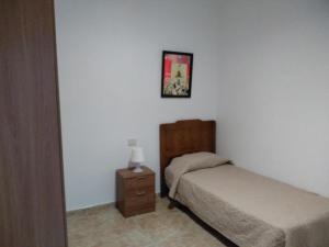 een slaapkamer met 2 bedden, een nachtkastje en een foto bij Apartamento para familias in Marzagán