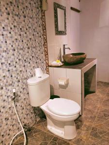 a bathroom with a toilet and a sink at The Lucky Cottage in Nusa Lembongan