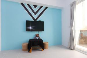 a blue room with a table and a tv on a wall at Fun Homestay in Ji'an