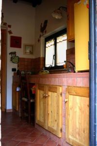 een keuken met houten kasten en een aanrecht bij Il Pozzo Romano in Vetralla