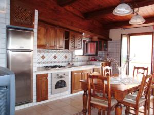 a kitchen with a table and chairs and a refrigerator at Villino Rosalia in Sperlonga