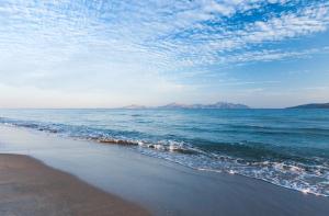 a beach with a view of the ocean and mountains at Caravia Beach Hotel in Marmari