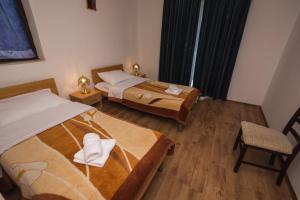 ein Hotelzimmer mit 2 Betten und einem Stuhl in der Unterkunft Pansion Kordić in Međugorje
