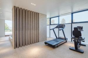 a gym with a treadmill and a chair in a room with windows at Hotel Privo in Târgu-Mureş