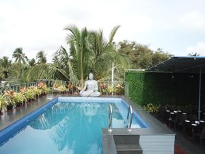 a buddha statue sitting next to a swimming pool at Leisure Cottages in Baga