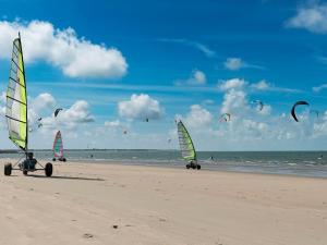 a group of people flying kites on the beach at Holiday Home Ganuenta-1 by Interhome in Colijnsplaat