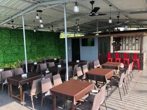 a patio with tables and chairs and a green wall at Leisure Cottages in Baga