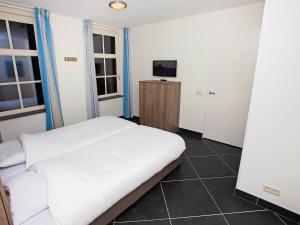 ColijnsplaatにあるHoliday Home Ganuenta-1 by Interhomeのベッドルーム(白いベッド1台、テレビ付)