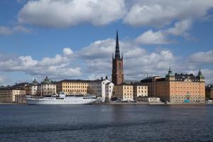 a cruise ship in the water in front of a city at Den Röda Båten in Stockholm