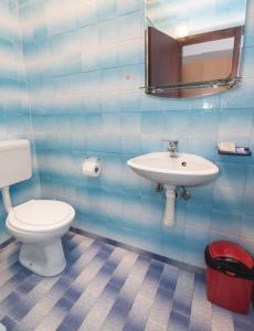 ein blau gefliestes Bad mit WC und Waschbecken in der Unterkunft Pansion Kordić in Međugorje