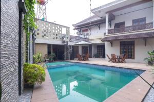 a swimming pool in the courtyard of a house at SUPER OYO 1421 Kasmaran Guest House Syariah in Jakarta