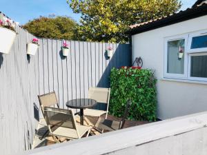 eine Terrasse mit 2 Stühlen und einem Tisch neben einem Zaun in der Unterkunft The Garden Room in Filey