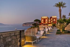 a row of chairs on a patio overlooking the ocean at Hotel Lorelei Londres in Sorrento