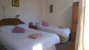 two beds in a room with pink pillows on them at Legends Hotel in Blackpool