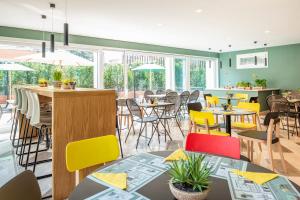 a dining room with tables and chairs and windows at Aparthotel Adagio Rome Vatican in Rome