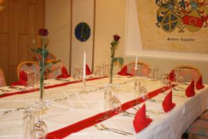 バート・ミュンダー・アム・ダイスターにあるThemen Hotel Terrassen Cafeの赤いナプキンと赤いリボンがついたテーブル