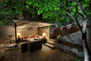 a patio with a couch and an umbrella at Relais 147 - Luxury b&b in Taormina