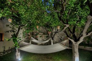 a hammock between two trees in a garden at Relais 147 - Luxury b&b in Taormina