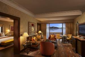 a hotel room with a bed and a living room at The Leela Palace Udaipur in Udaipur