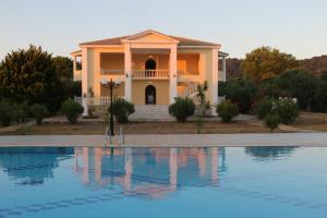 una casa con piscina frente a ella en Stamiris Beach Hotel, en Vasilikos