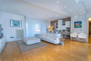 a living room with a white couch and white chairs at Teatro Nuovo Apartment with Free Parking in Udine