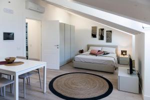 a white bedroom with a bed and a table at Paduina3 Comfort Apartments in Trieste