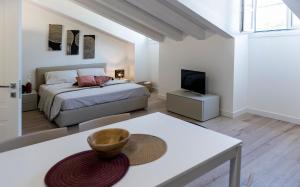 a white bedroom with a bed and a tv at Paduina3 Comfort Apartments in Trieste