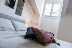 ein Schlafzimmer mit einem Bett mit einem Kissen darauf in der Unterkunft Paduina3 Comfort Apartments in Triest